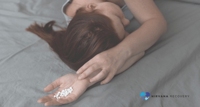 A woman lying on a bed with pills in her hand, symbolizing the lethal respiratory effects of Fentanyl overdose, highlighting its extreme danger and potential for fatal consequences.