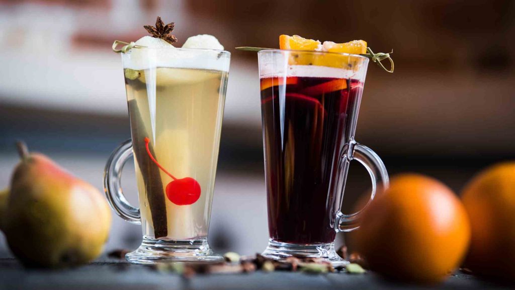 Two sweet, high-carb cocktails garnished with fruit, symbolizing alcoholic drinks to avoid on a keto diet.