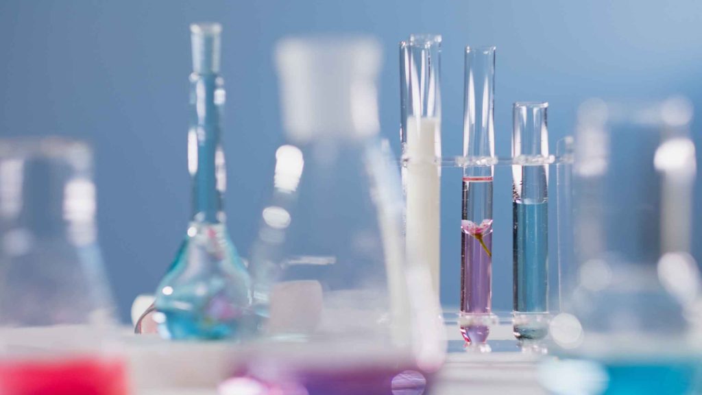 Laboratory glassware with colorful liquids, symbolizing drug testing and Suboxone detection in the body.