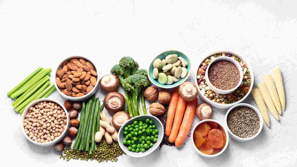 Assorted vegetables, nuts, legumes, and seeds displayed, showing a nutritious diet to help prevent fever and chills after alcohol.