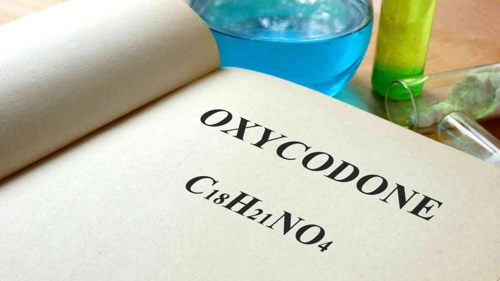 Open book showing the word “Oxycodone” with its chemical formula, symbolizing discussion on mixing hydrocodone and oxycodone.