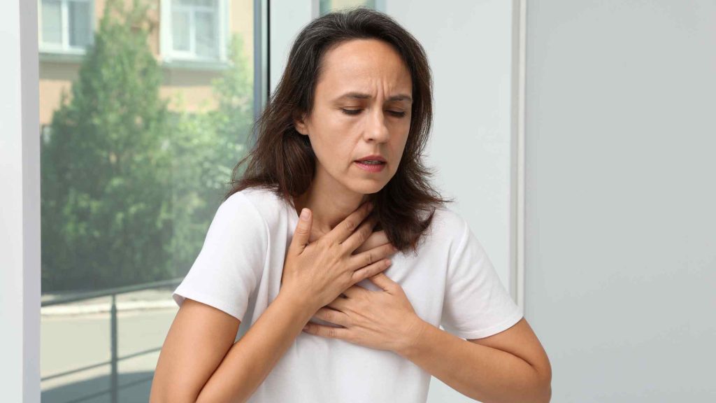 Woman having difficulty in breathing openly, symbolizing the possible side effects and health risks of combining hydrocodone and oxycodone.