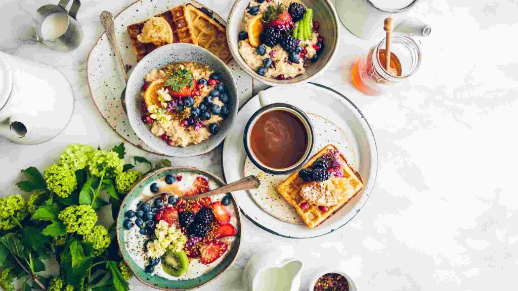 Healthy breakfast with oatmeal, waffles, fruit, and tea, symbolizing balanced nutrition for preventing future health episodes.