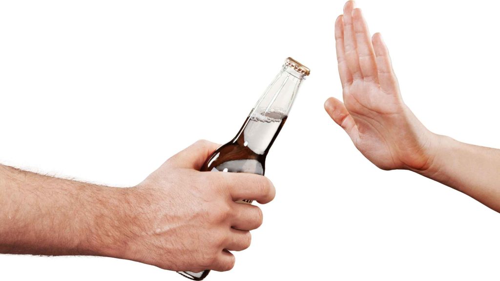 Person refusing a bottle of beer, symbolizing prevention and lifestyle changes to avoid alcoholic gastritis.