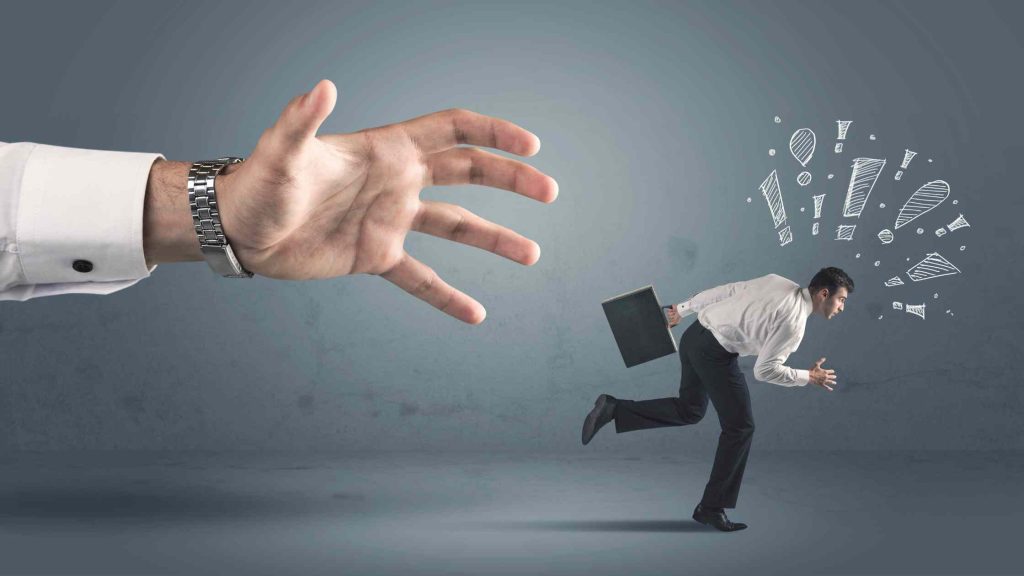 A businessman running from a large hand, symbolizing the consequences of gabapentin addiction.