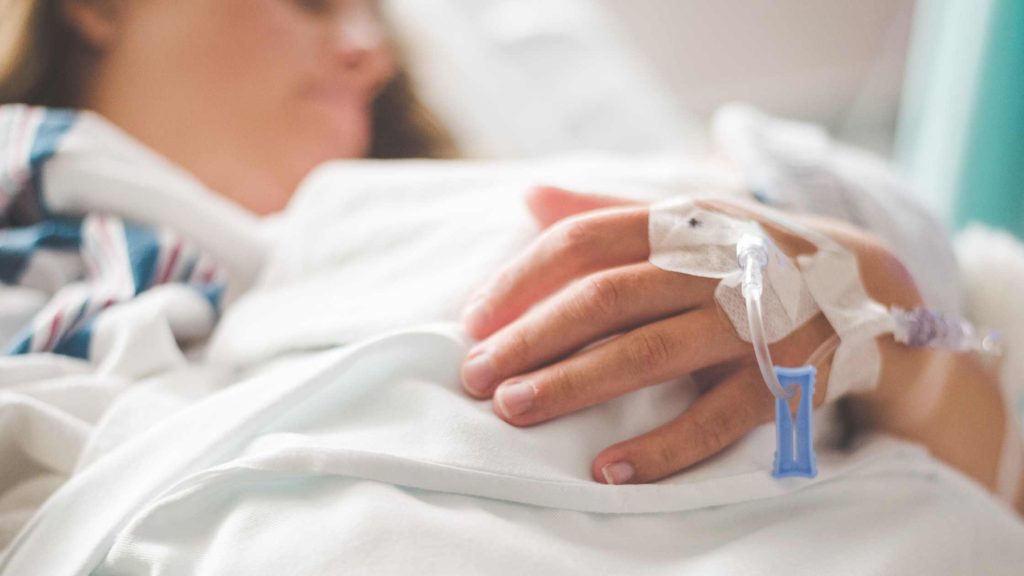 Patient resting in hospital bed, representing Blue Cross-covered detox options like inpatient residential treatment.
