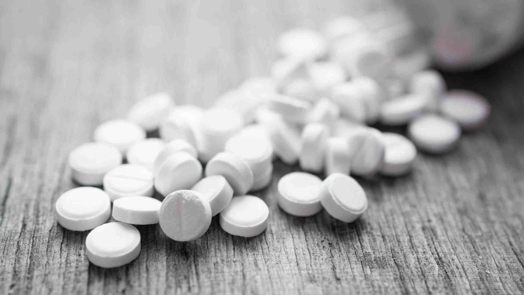 Opioid pills on a table symbolizing opioid use disorder, a condition that qualifies for short-term disability during rehab.