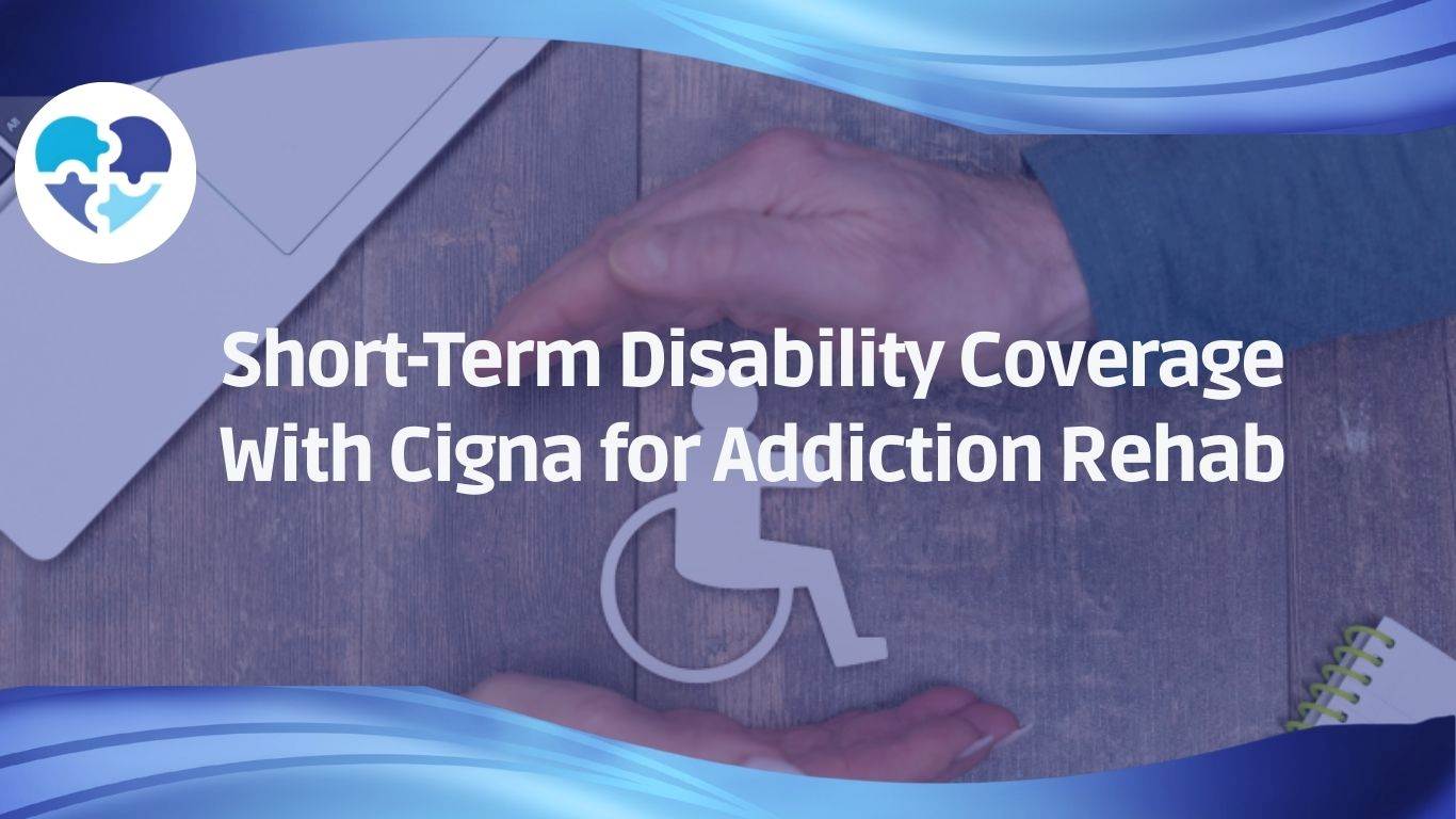 Hands cupping a paper wheelchair icon on a desk, symbolizing Cigna short-term disability coverage for rehab.