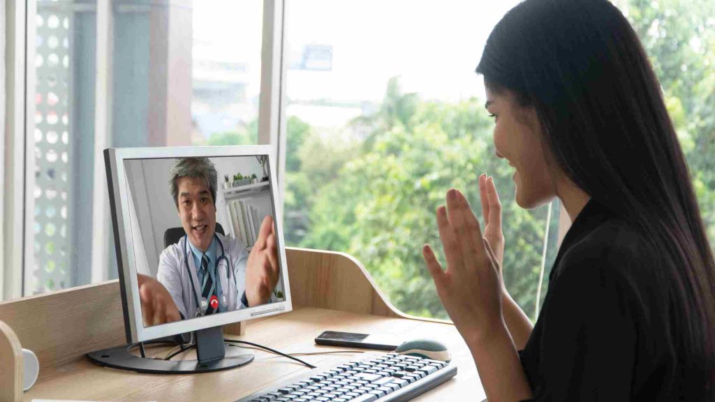 Woman in an online session with a doctor, representing Blue Cross-covered virtual outpatient care programs in Arizona.