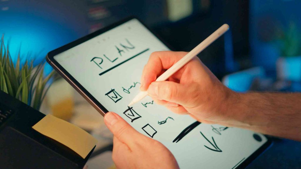 Person writing a plan checklist on a tablet, representing preparation and organization for understanding Cigna PPO plans.