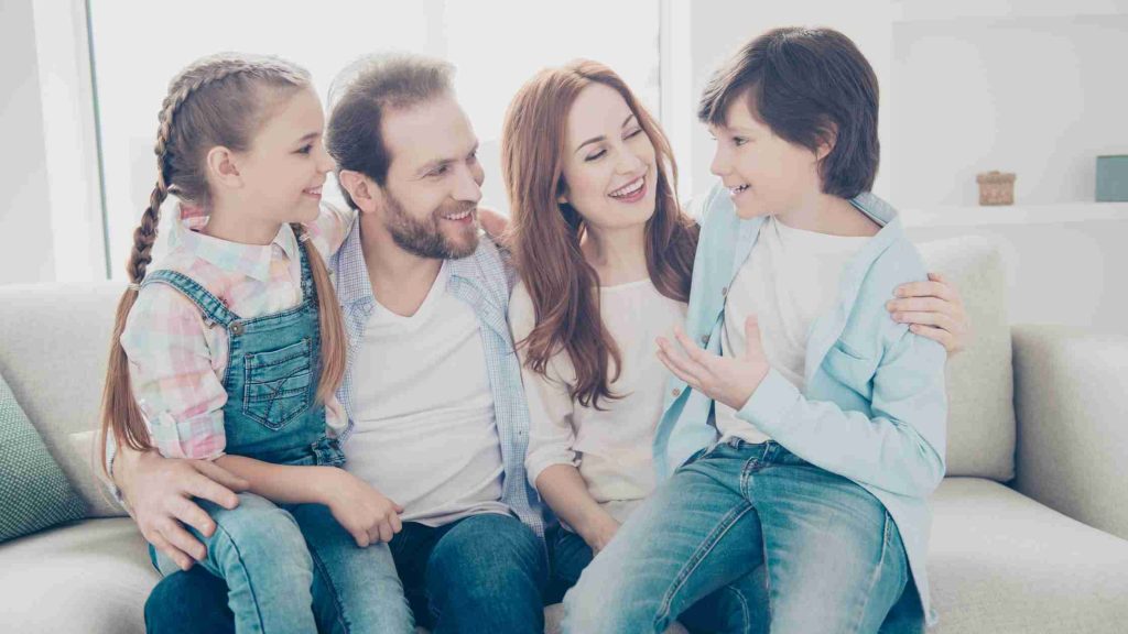 Happy family sitting together, symbolizing Blue Cross family plans covering detox and alcohol rehab for supportive recovery.