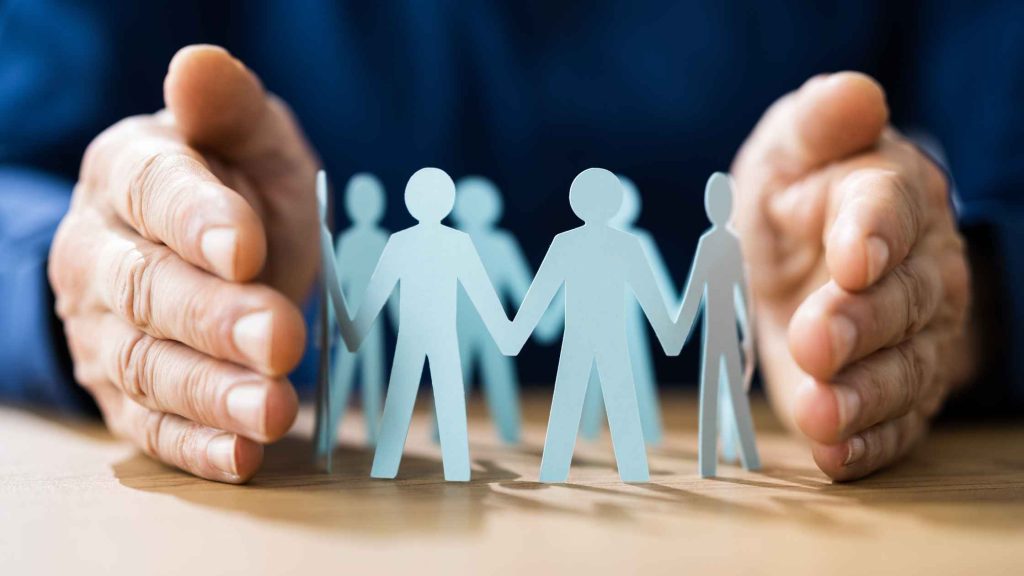 Hands shielding paper cutout people, symbolizing federal protections for employees seeking opioid rehab rights.