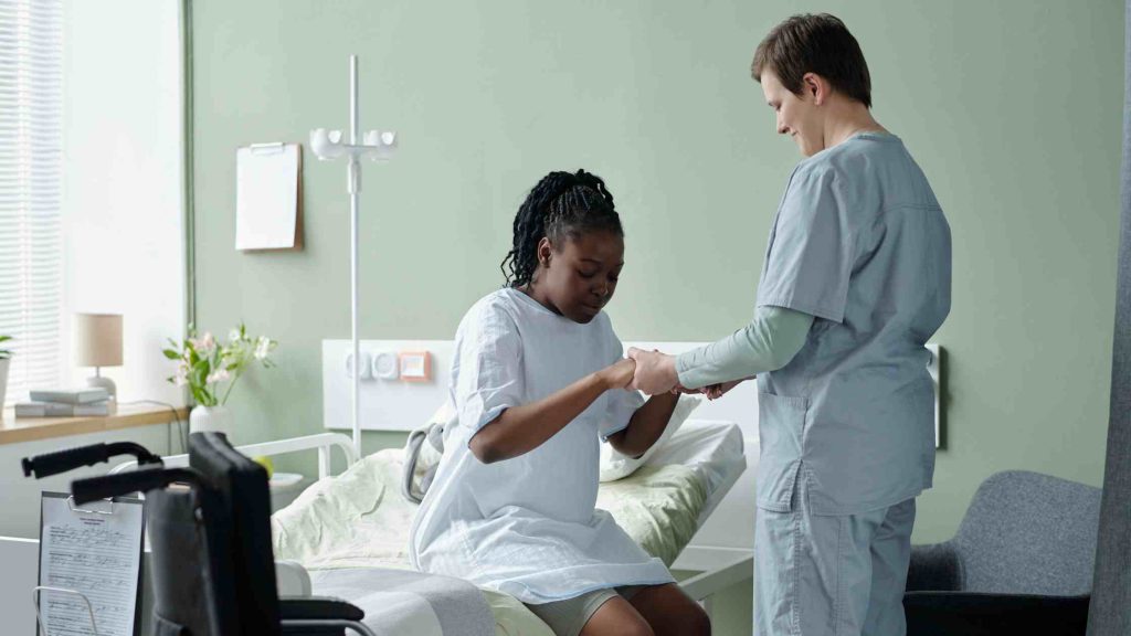 Nurse assisting a patient in a hospital room, symbolizing Aetna PPO coverage for inpatient rehab treatment in Arizona.