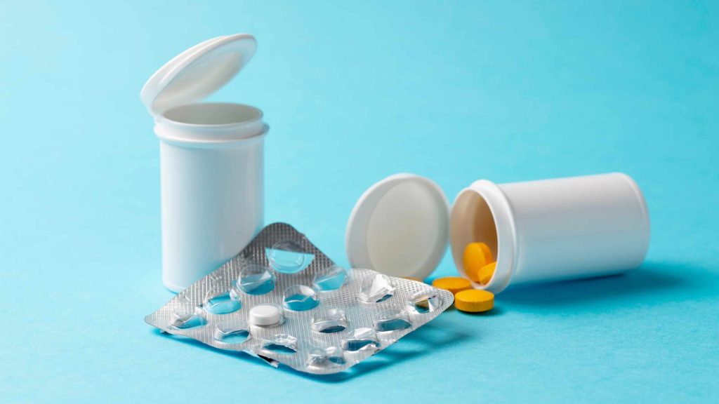 Open pill bottles and scattered tablets shows myth that Blue Cross rehab coverage only applies to opioid addiction treatment.