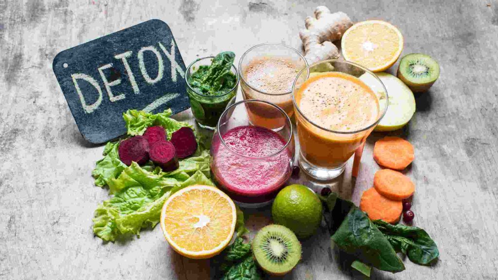 Fresh fruits and detox juices beside a “DETOX” sign, symbolizing Blue Cross coverage for detox and rehab services in Arizona.