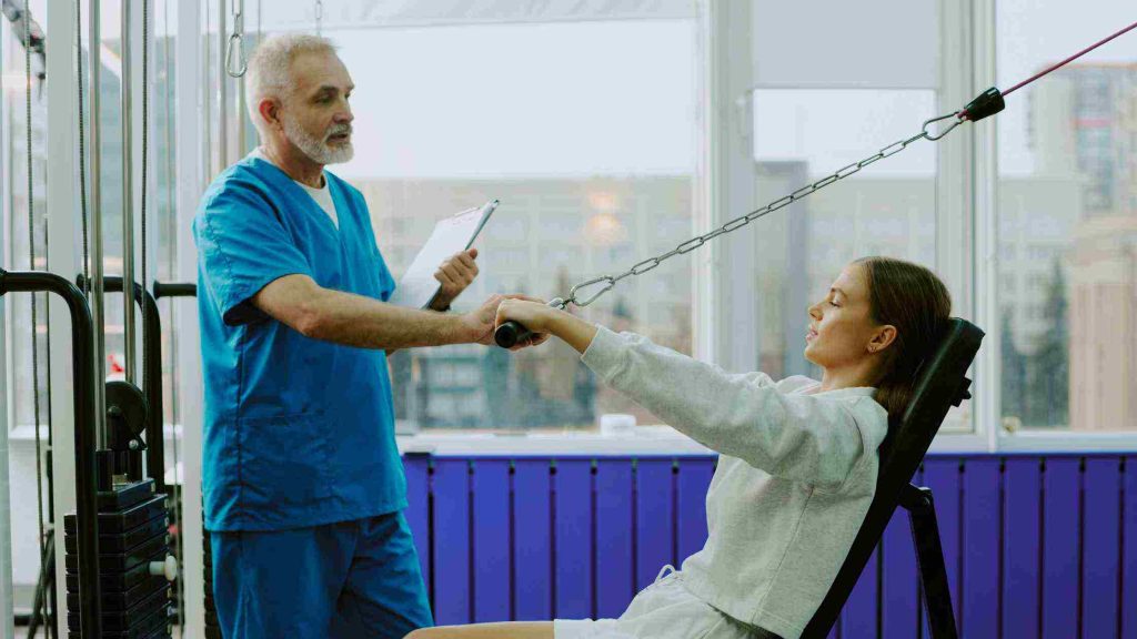Doctor assisting a young woman with rehab exercises, representing inpatient PPO insurance coverage for Opioid Rehab in Arizona.