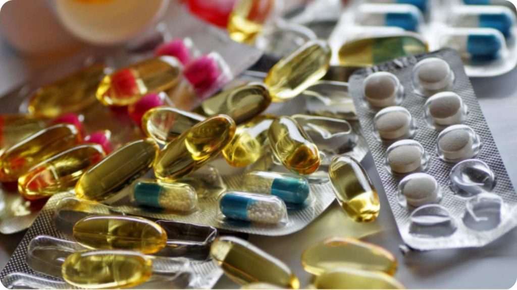 Assorted prescription pills and capsules scattered on a table.