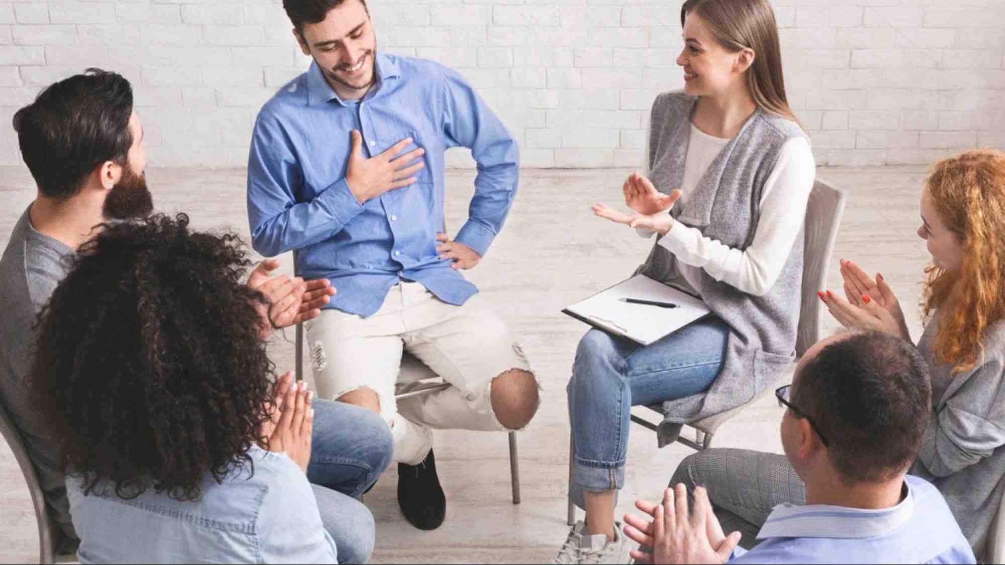 Support group applauding recovery progress as former rehab patients rebuild confidence, routines, and prepare for work.